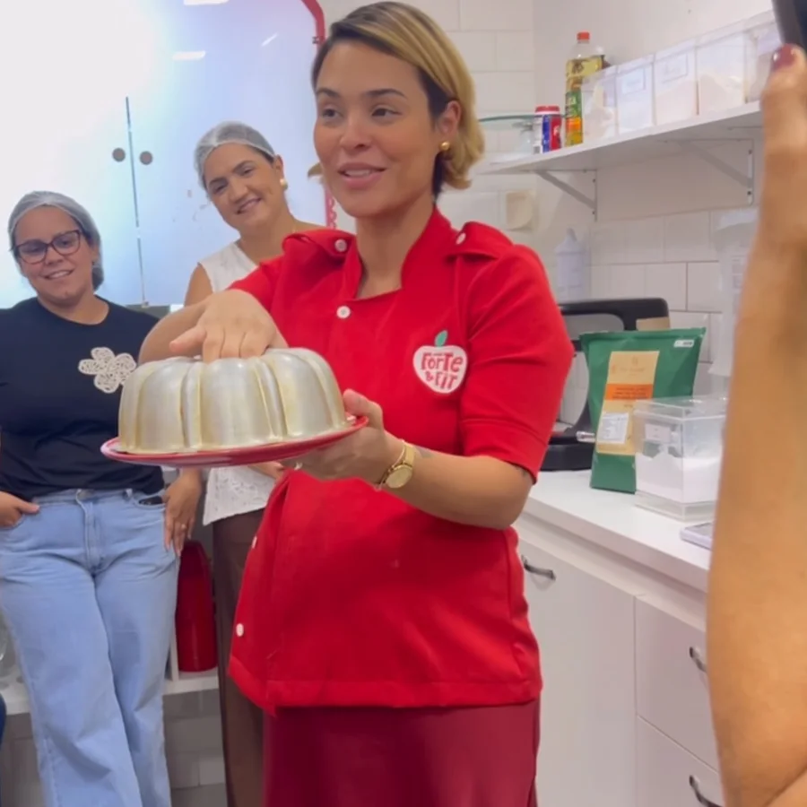 Gabriela Costa com um bolo na cozinha da Forte & Fit durante um curso